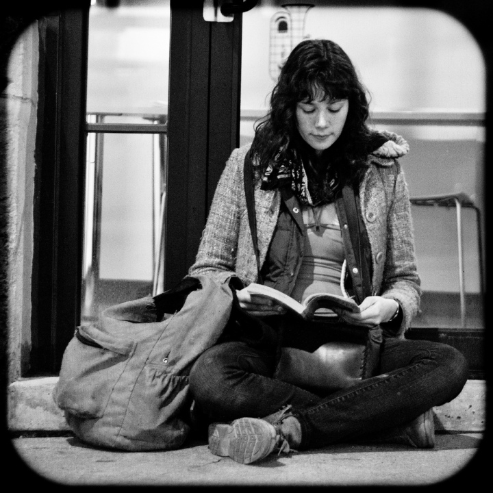 Girl reading at the bus stop